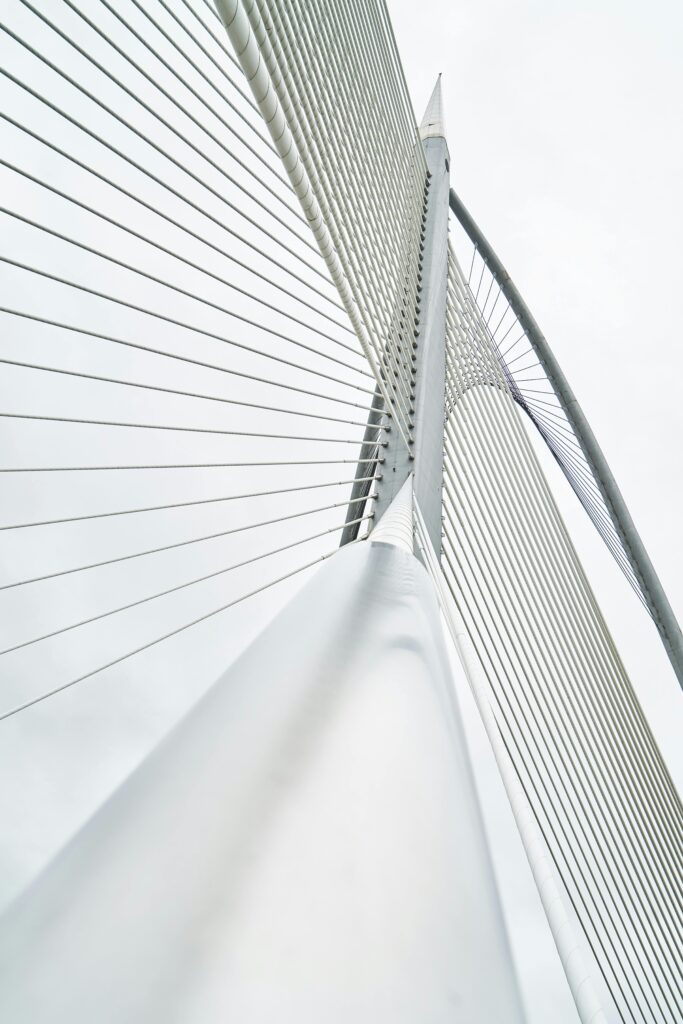 pexels-photo-434659-434659 Low angle view of a modern suspension bridge with steel cables and architectural lines under a cloudy sky.
